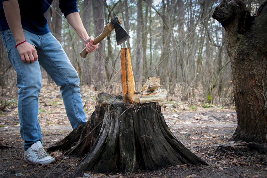 Человек с топором занимается колкой дров