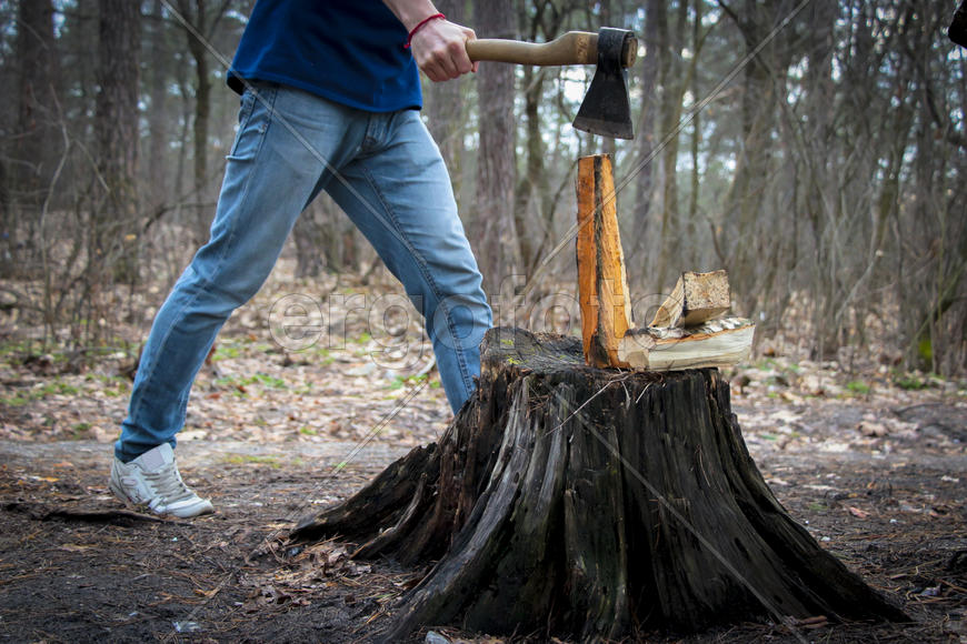 Человек с топором занимается колкой дров