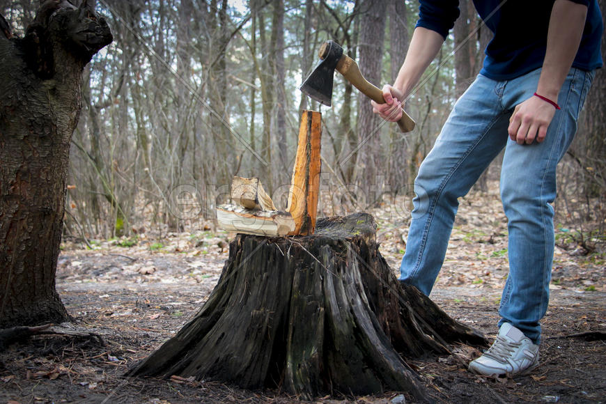 Человек с топором занимается колкой дров