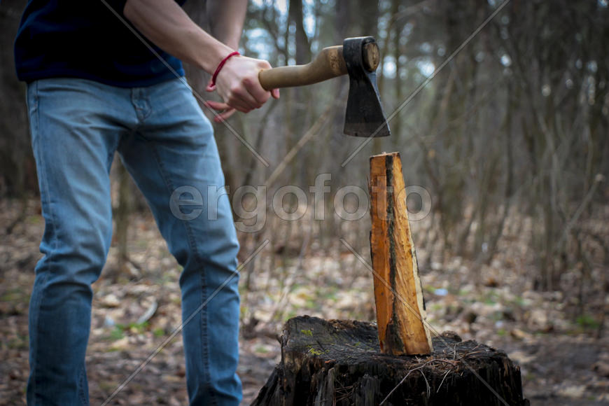 Человек с топором занимается колкой дров