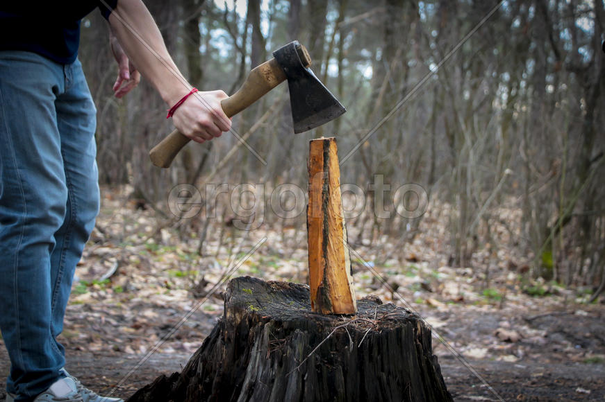 Человек с топором занимается колкой дров