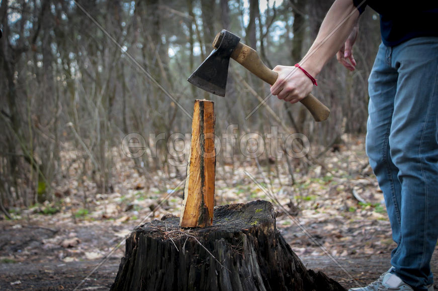 Человек с топором занимается колкой дров