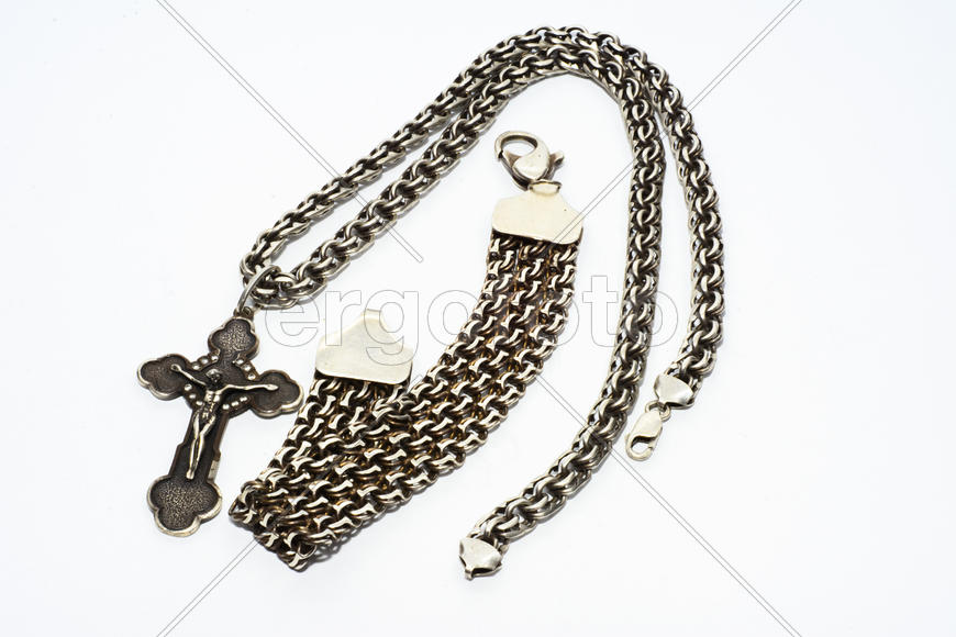 Браслеты, цепочки и кресты из серебра на белом фоне