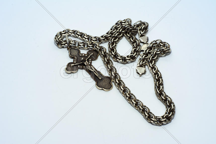 Браслеты, цепочки и кресты из серебра на белом фоне