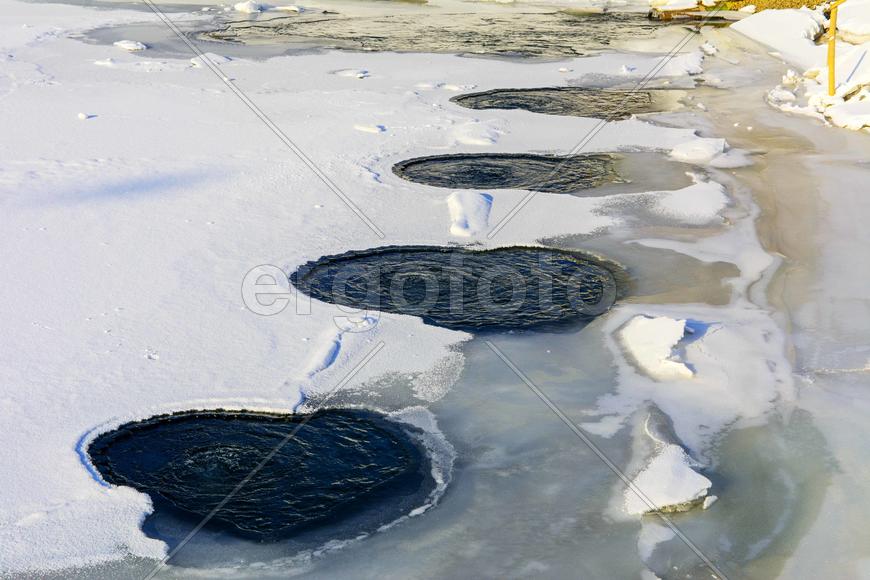 Теплая вода на льду замерзшего озера