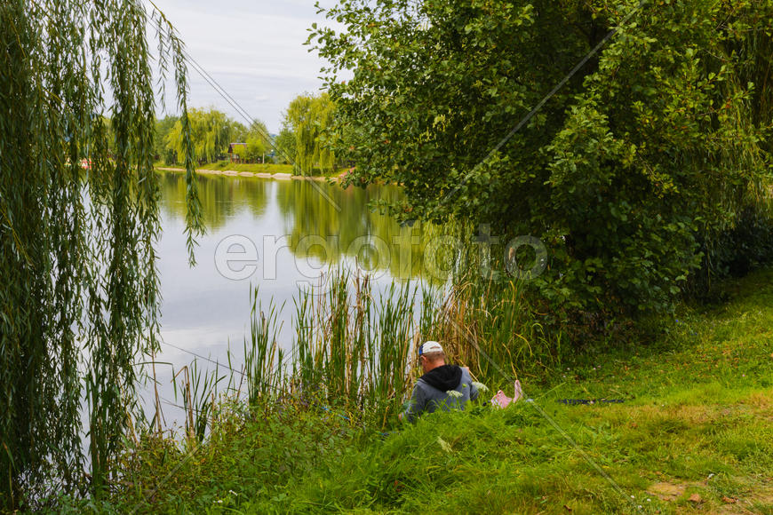 Рыбак с удочкой на берегу горного озера