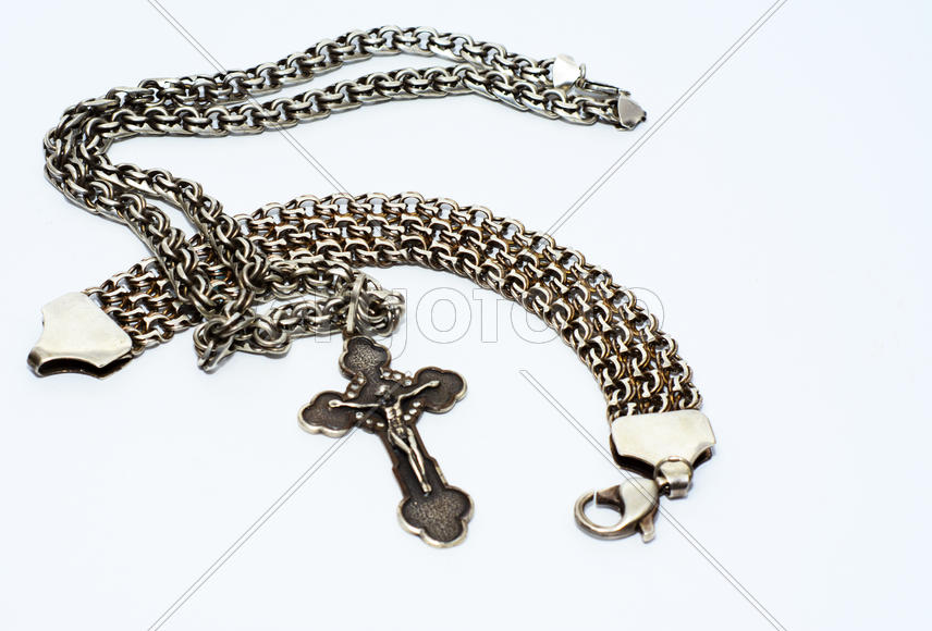 Браслеты, цепочки и кресты из серебра на белом фоне