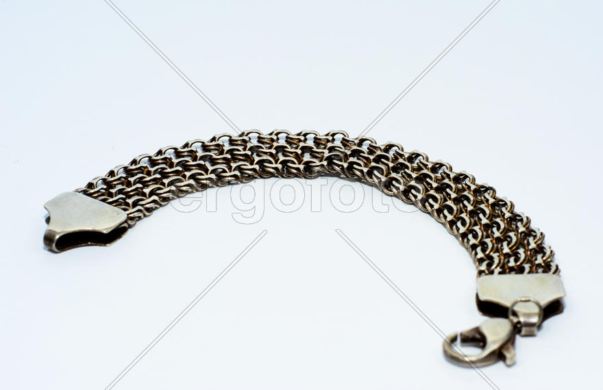 Браслеты, цепочки и кресты из серебра на белом фоне