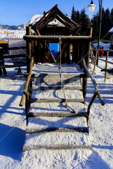 Детские качели и горки в снегу зимой