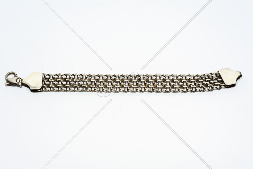 Браслеты, цепочки и кресты из серебра на белом фоне