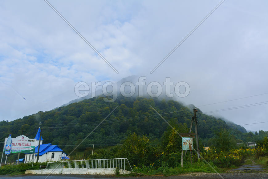 Горный поселок с видом на затуманенную вершину 