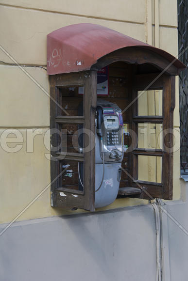 Phone booth on the wall of an apartment house in the city