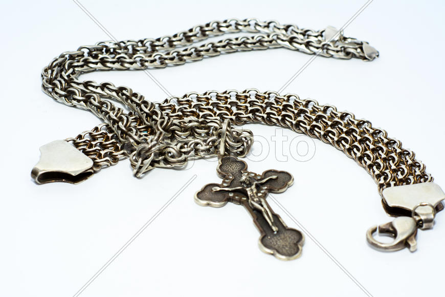 Браслеты, цепочки и кресты из серебра на белом фоне