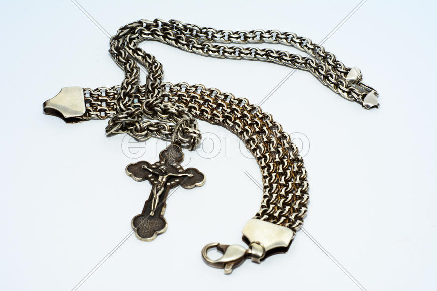 Браслеты, цепочки и кресты из серебра на белом фоне