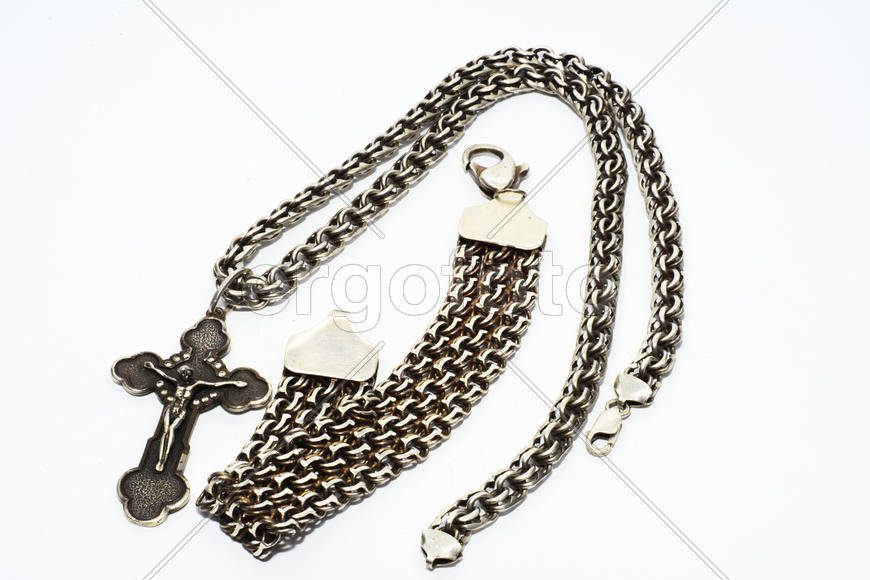 Браслеты, цепочки и кресты из серебра на белом фоне