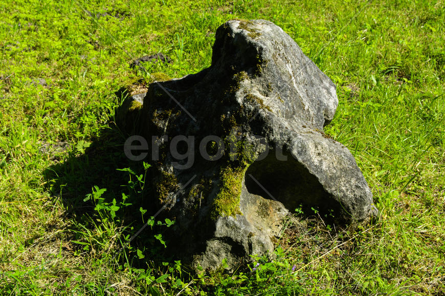 Big old stone on the grass in the park
