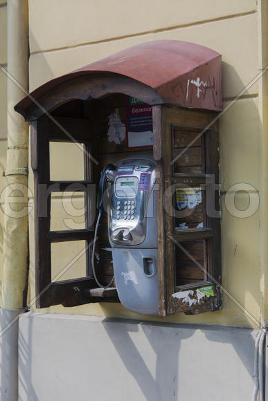 Phone booth on the wall of an apartment house in the city