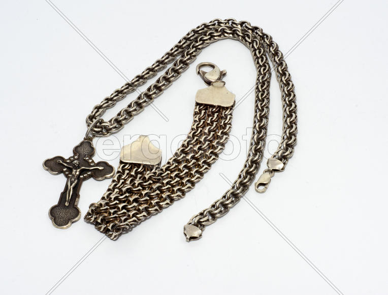 Браслеты, цепочки и кресты из серебра на белом фоне