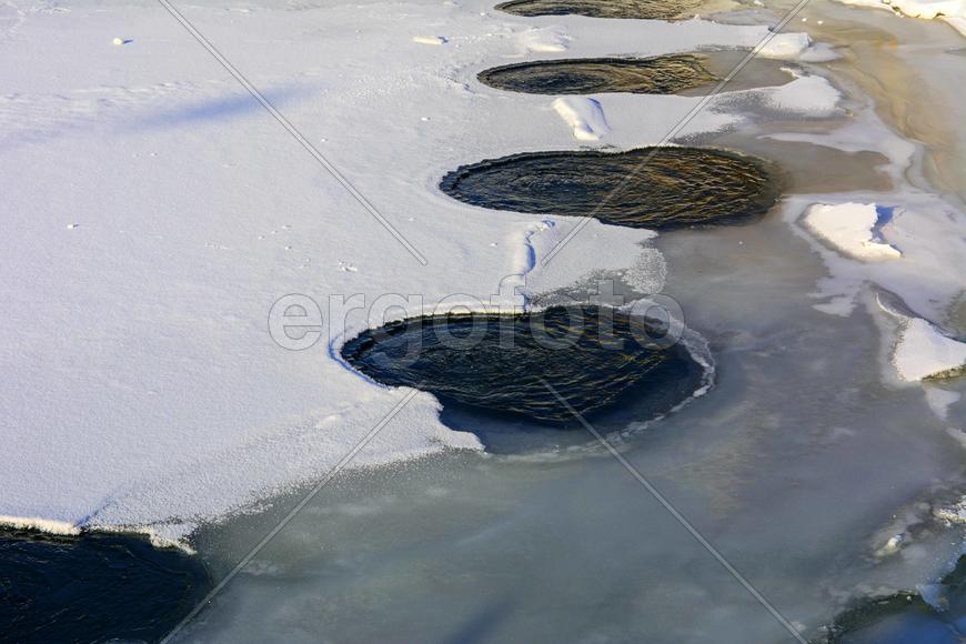 Теплая вода на льду замерзшего озера
