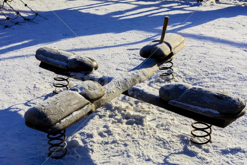 Детские качели и горки в снегу зимой