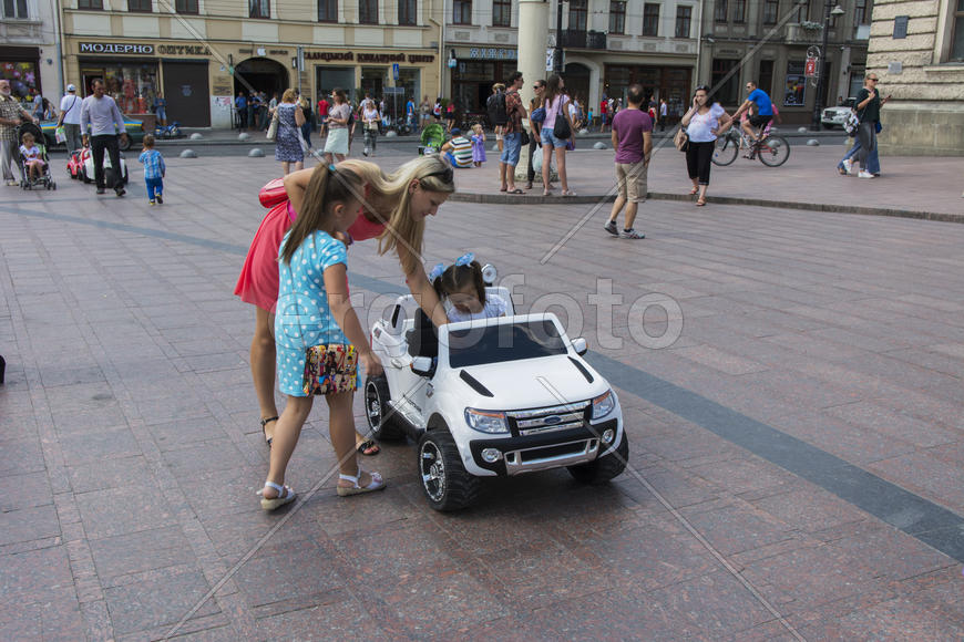 A child in a baby machine in city park