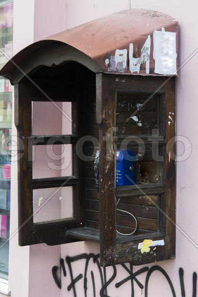 Phone booth on the wall of an apartment house in the city