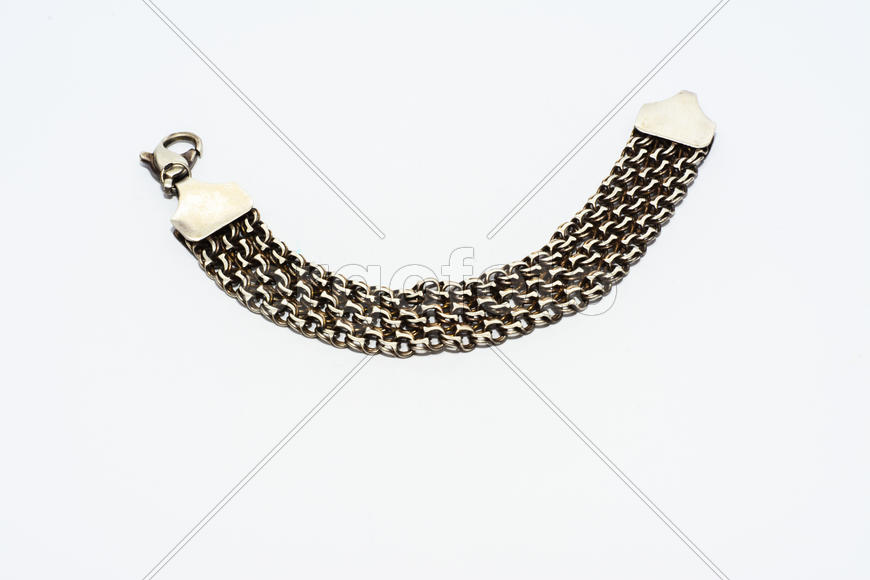 Браслеты, цепочки и кресты из серебра на белом фоне