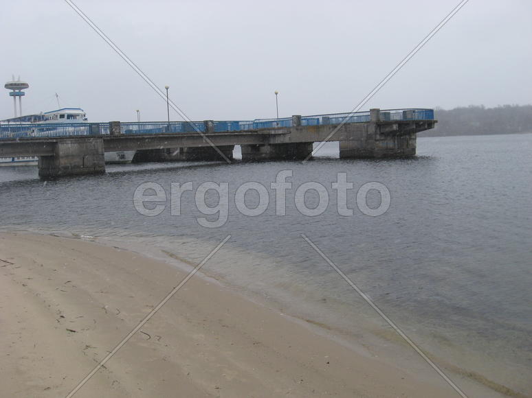 Причал с голубым забором и теплоходом на заднем плане
