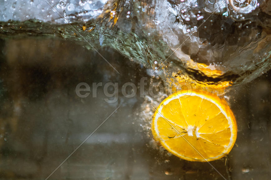 Ломтики апельсина падающие в воду 