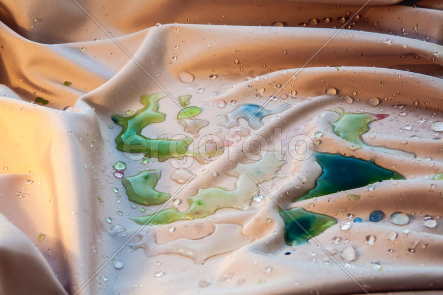 Маленькие капли воды на бежевой ткани