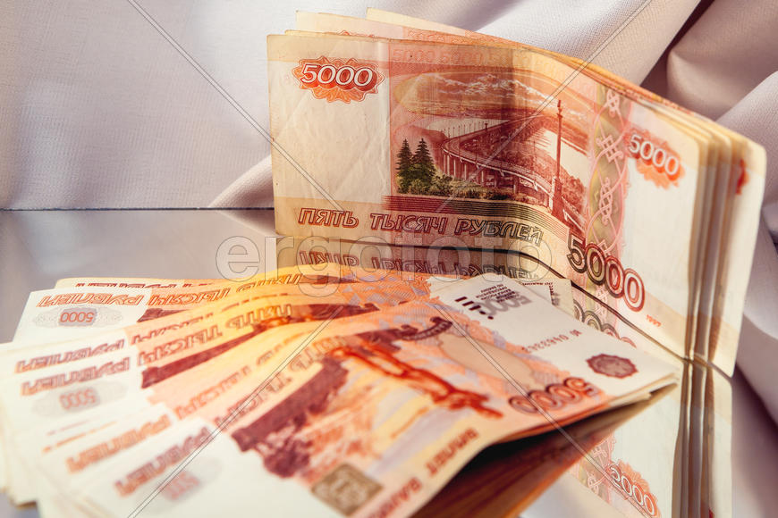 Пятитысячные купюры отражаются в зеркале