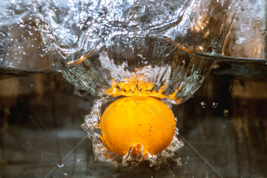 Апельсин падающий в сосуд с водой 