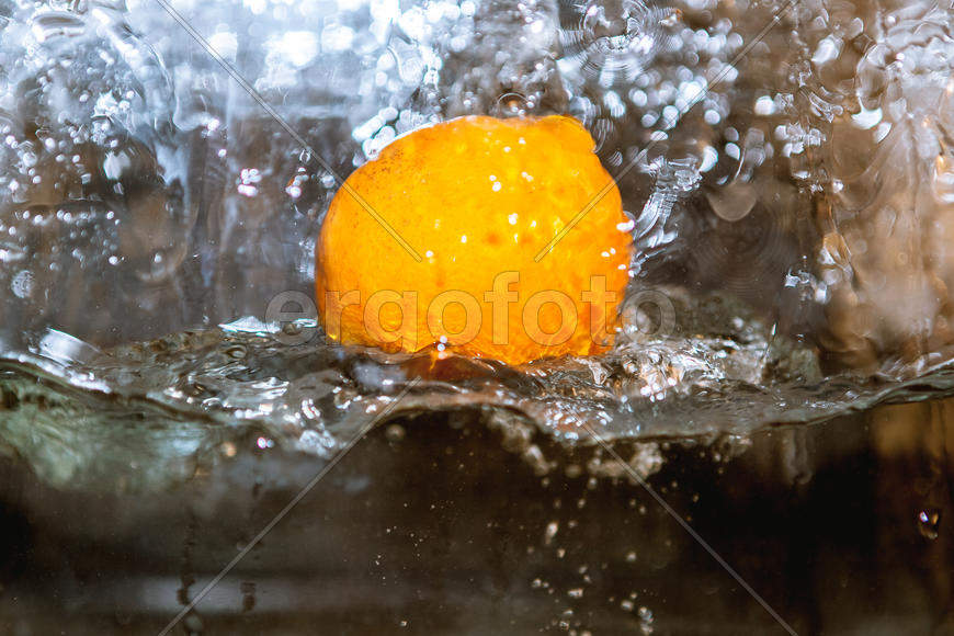 Апельсин падающий в сосуд с водой 