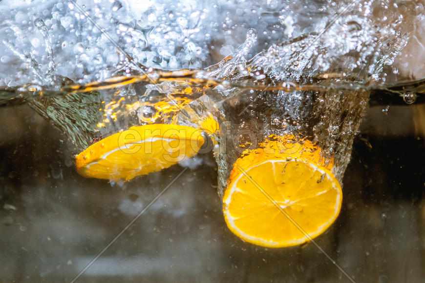 Ломтики апельсина падающие в воду 