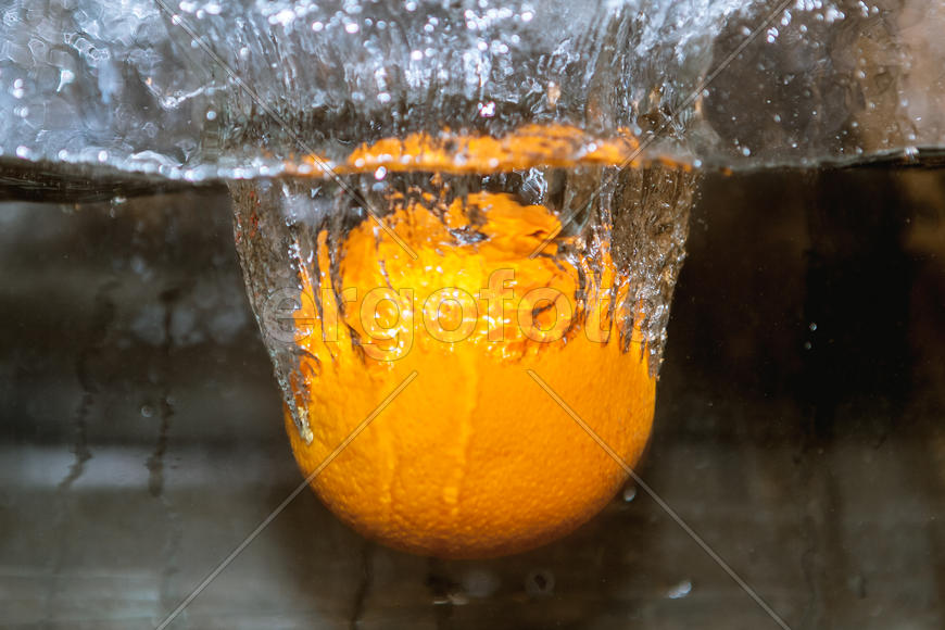 Апельсин падающий в сосуд с водой 