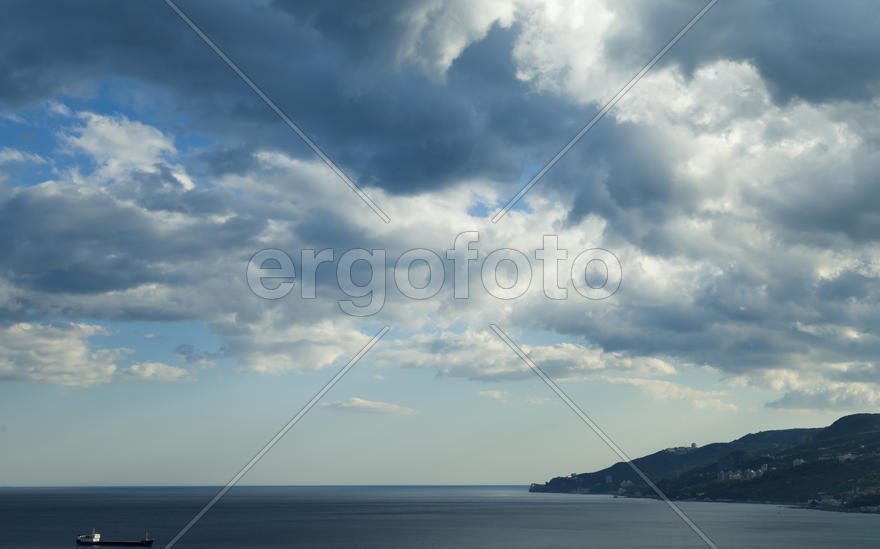 Clouds over mountains majestically float towards the sea