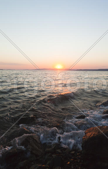 The sea at sunset in beams of the red setting sun