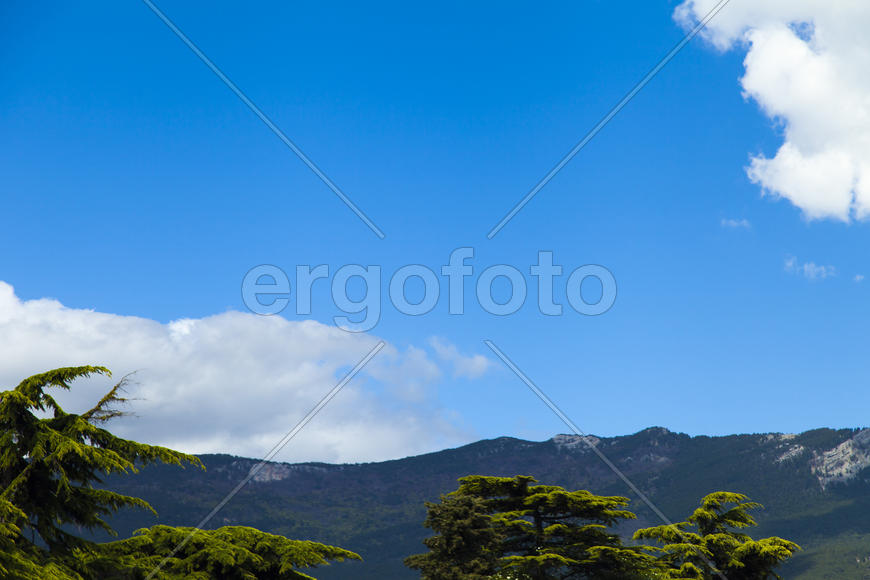 Clouds over mountains majestically float towards the sea