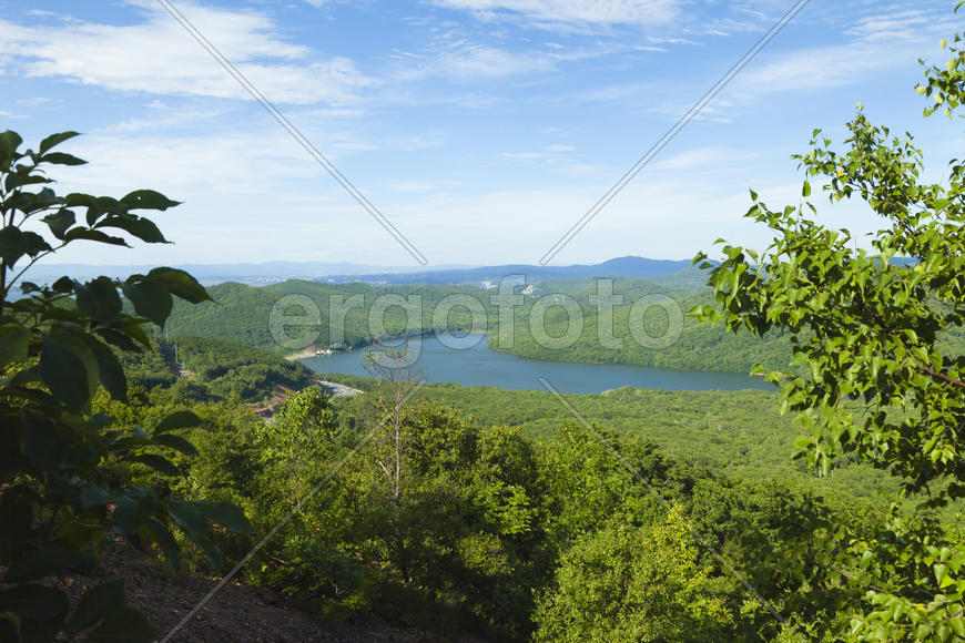 Green hills under the blue sky in beams of a bright sun