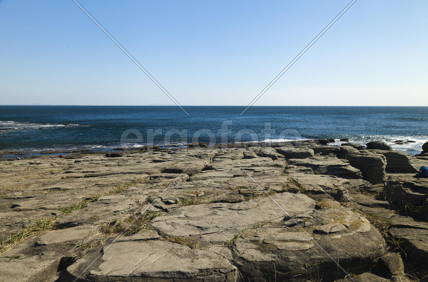 Rocks and sea meet in the bright sunlight in autumn