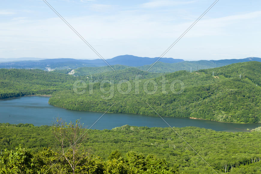Green hills under the blue sky in beams of a bright sun