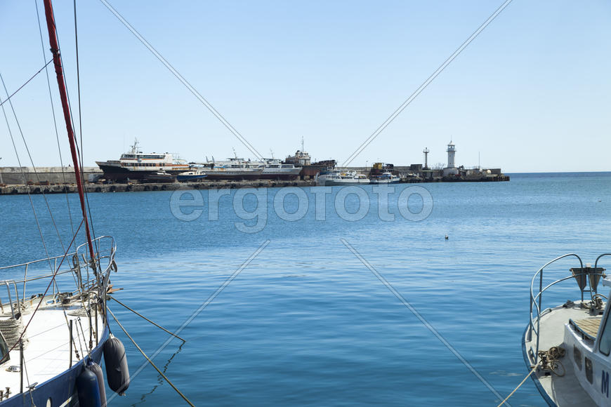 City bay with the ships in it under the blue sky and a bright sun