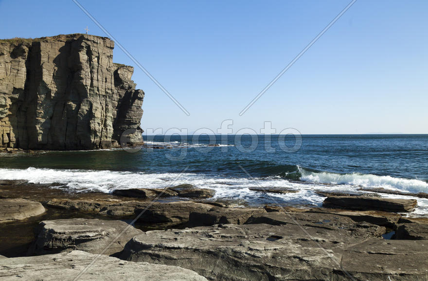 Rocks and sea meet in the bright sunlight in autumn