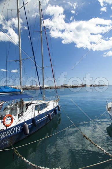 City bay with the ships in it under the blue sky and a bright sun