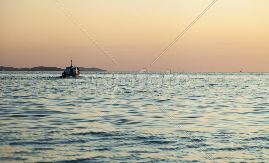 The sea at sunset in beams of the red setting sun