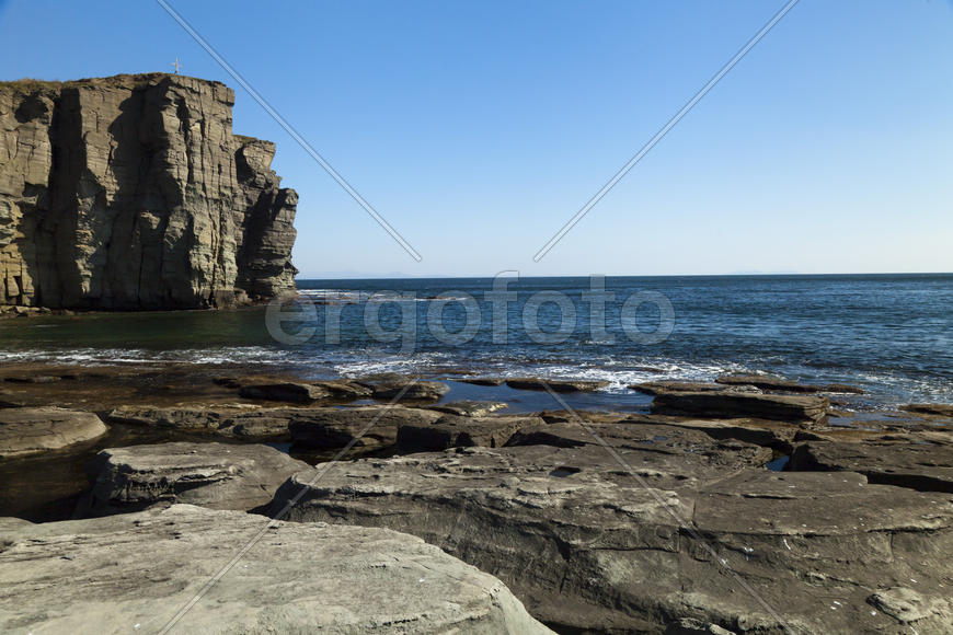 Rocks and sea meet in the bright sunlight in autumn