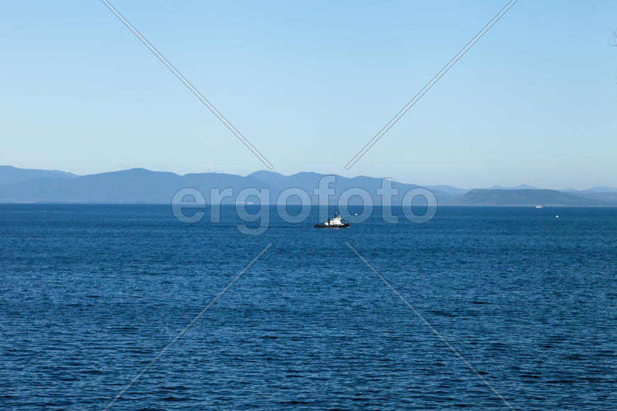 Seascape with ships and mountains on the horizon a bright sunny day