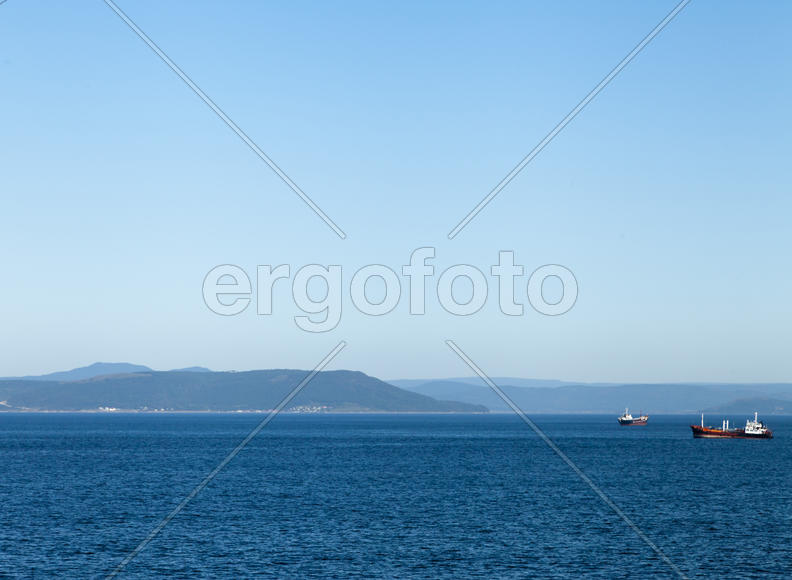 Seascape with ships and mountains on the horizon a bright sunny day