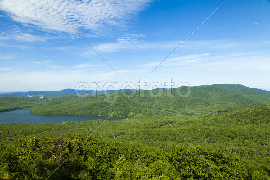Green hills under the blue sky in beams of a bright sun