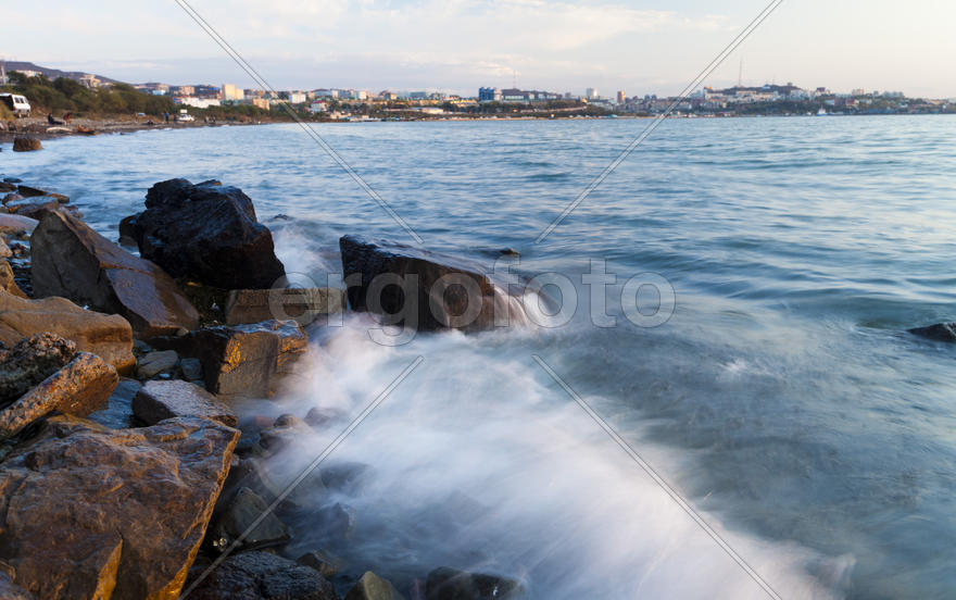 The sea at sunset in beams of the red setting sun